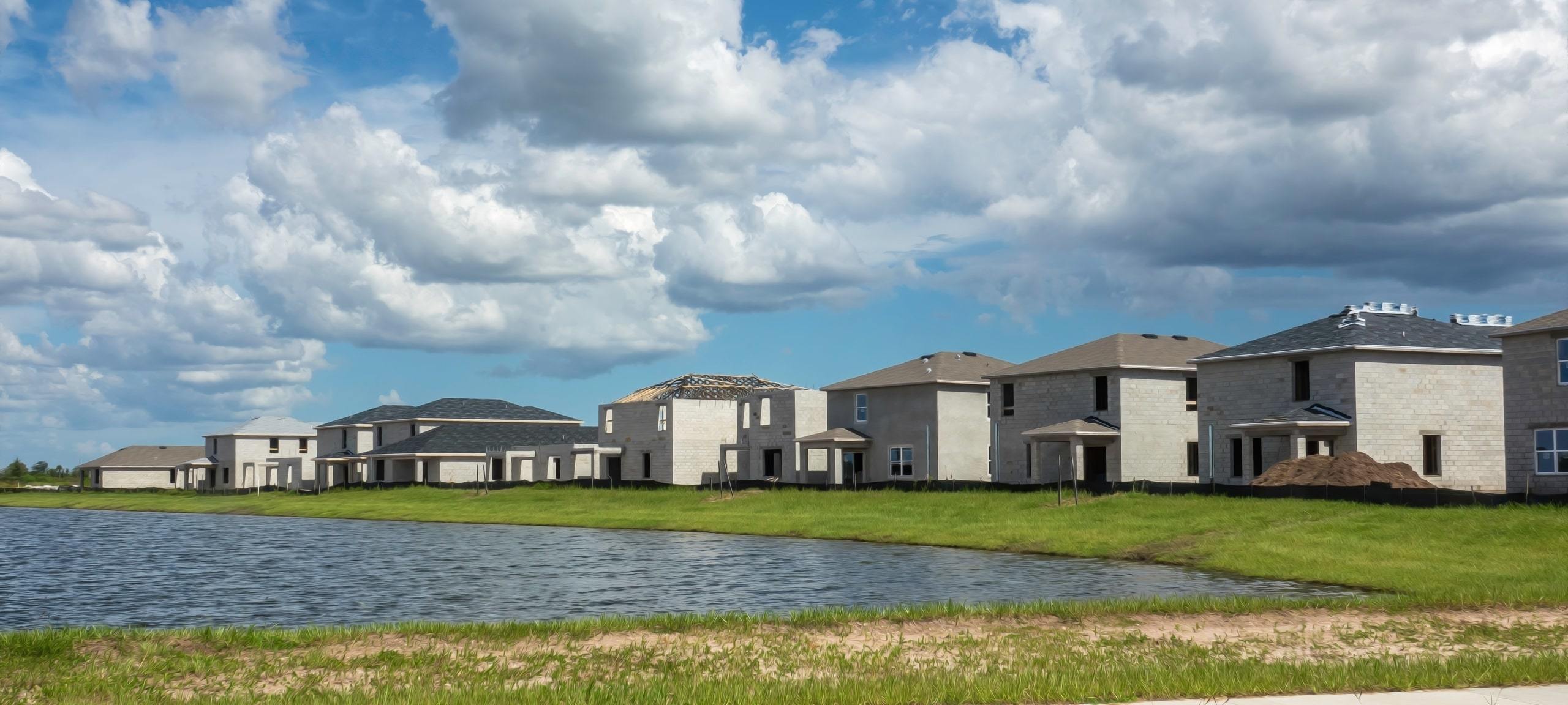 New construction homes on man-made lake, typical of Royal Legacy Estates